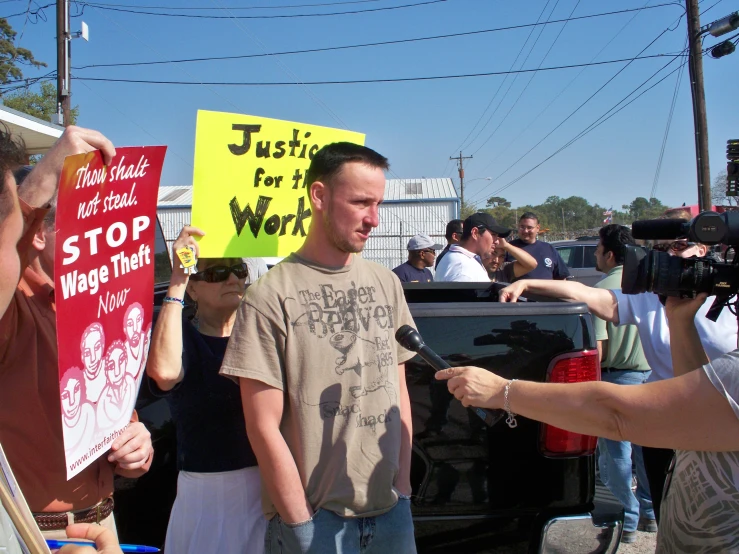 a man holding up a yellow sign and talking to someone