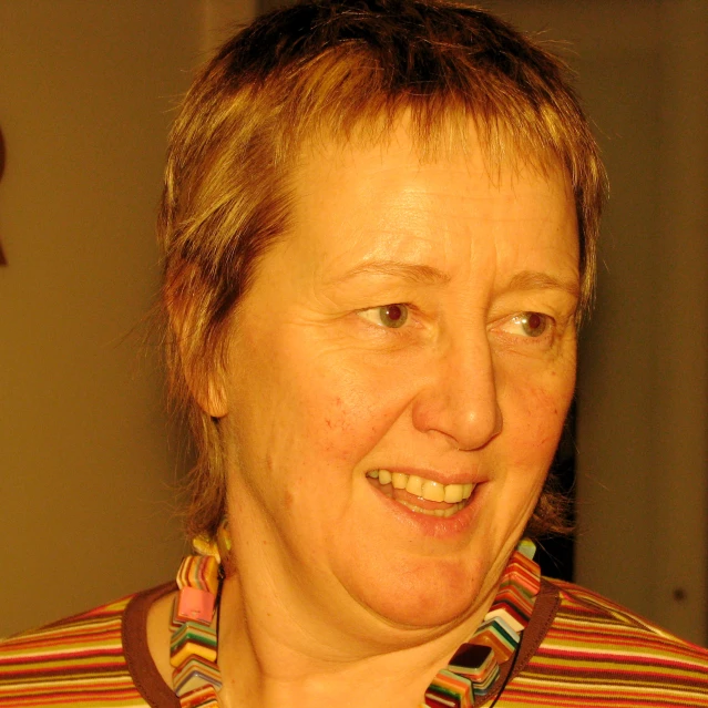 an older woman is smiling with large earrings on her neck