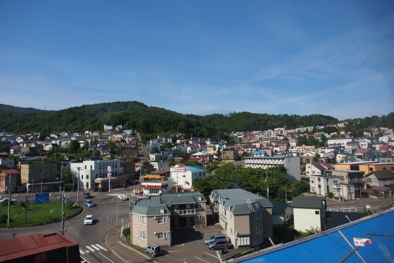 a city surrounded by green hills with houses