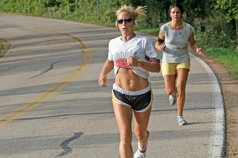 two women running down the street with their running equipment