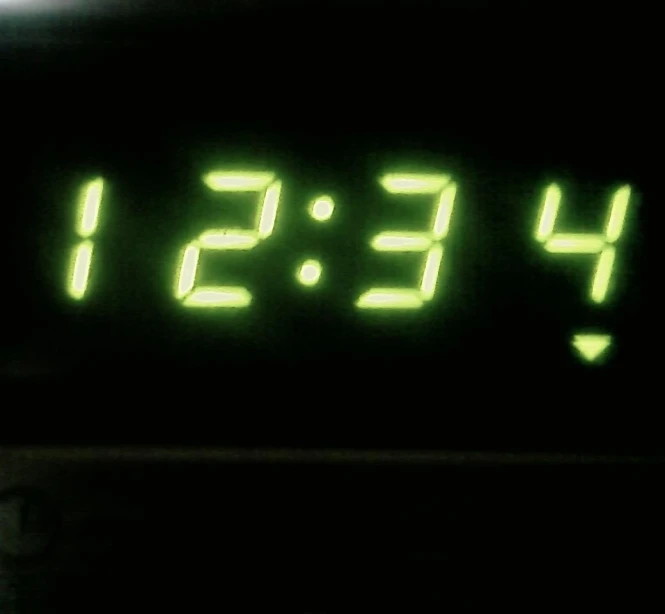 the digital clock indicates noon hours to four pm