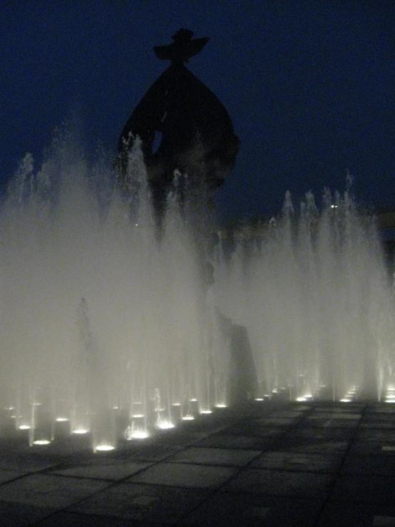 water is flowing out of the fountain at night