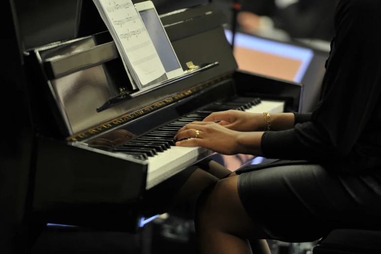 a person sitting at a piano that is playing music