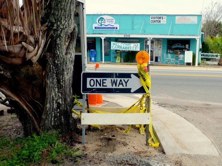 a sign posted at a street corner for one way