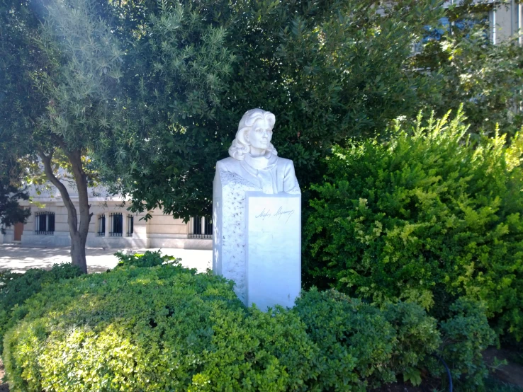 a statue of an old man surrounded by bushes