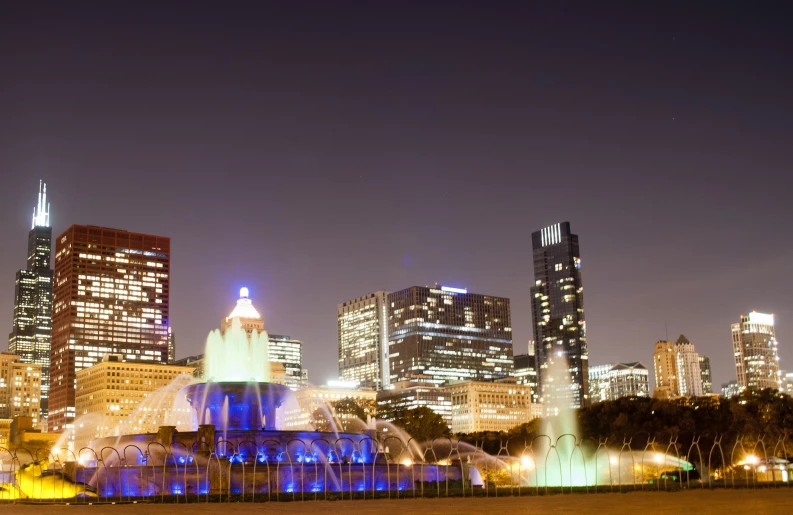 night s of a large water fountain in front of several skyscrs