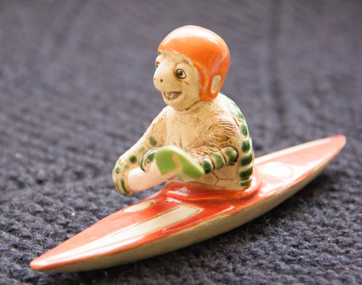 a plastic monkey surfer on top of a surfboard