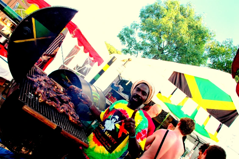 two men in gay rainbow shirts stand by a grill