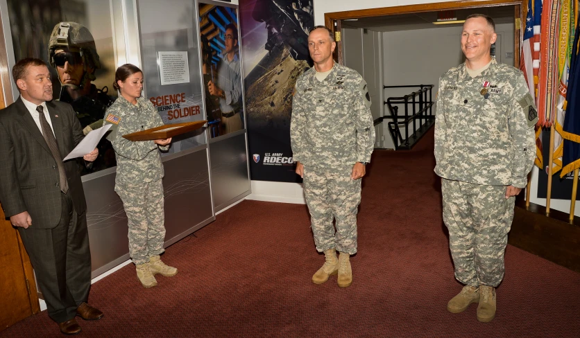 two army men are smiling while standing in front of other men