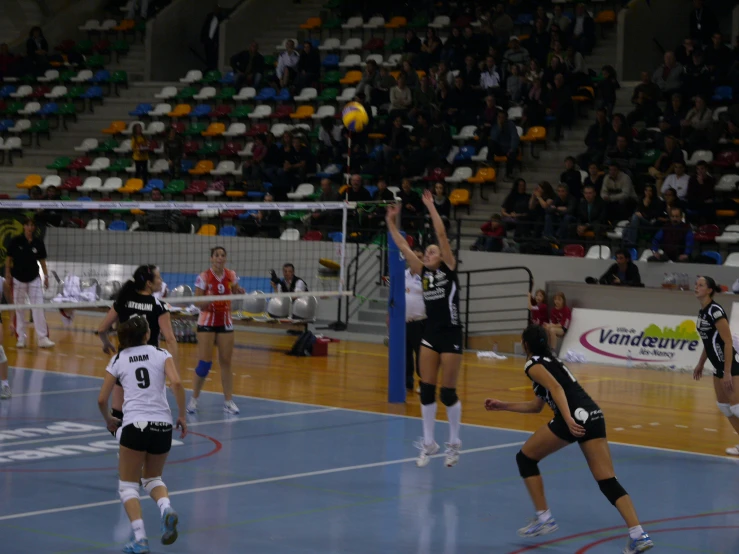 volleyball players are jumping for the ball on a court