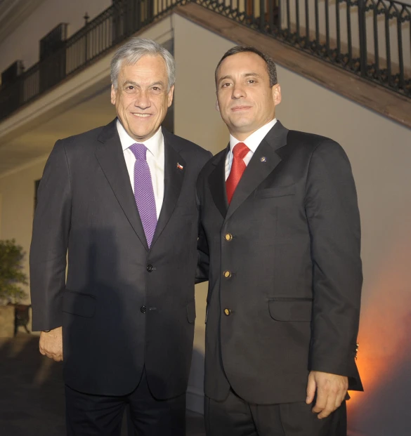 two men dressed in suits standing by each other