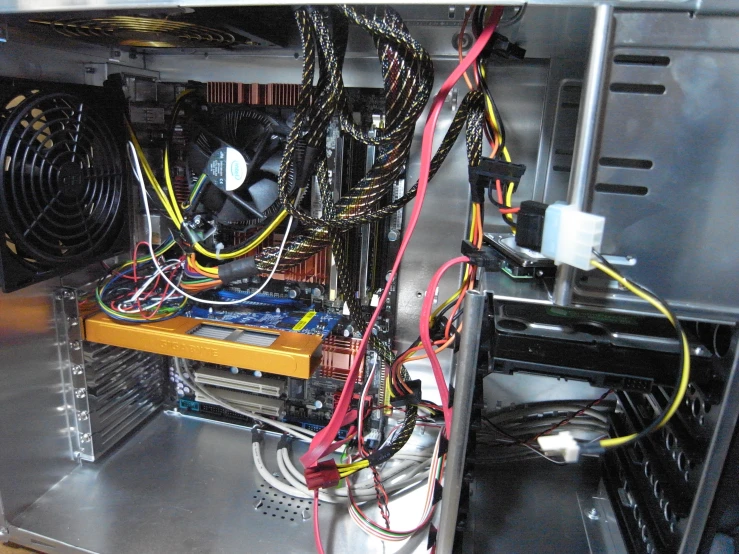 a bunch of wires hanging off the side of a computer tower