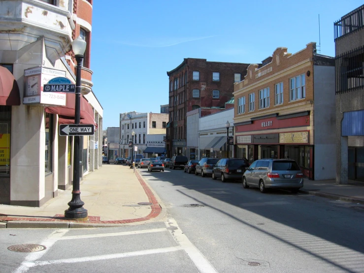 an empty street is shown with cars and signs