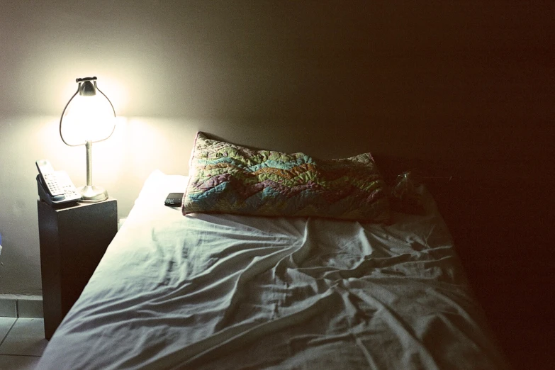 a small lamp on the nightstand beside a bed