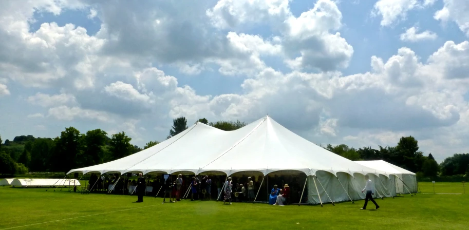 an event tent setup with many people standing outside it