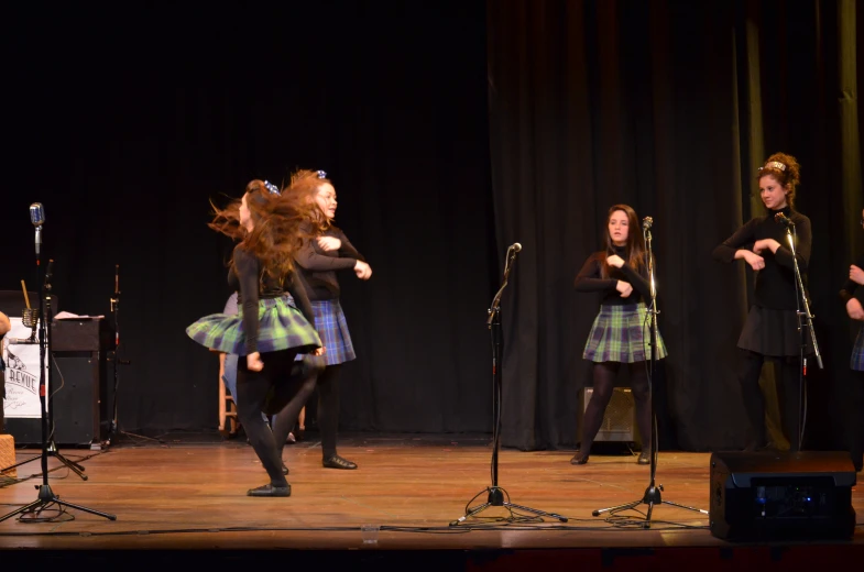 group of women performing on stage in school uniform