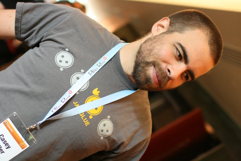 a smiling man wearing a gray t - shirt