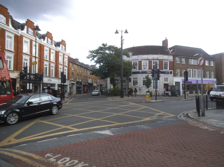 a black car is parked in the middle of a road with other vehicles