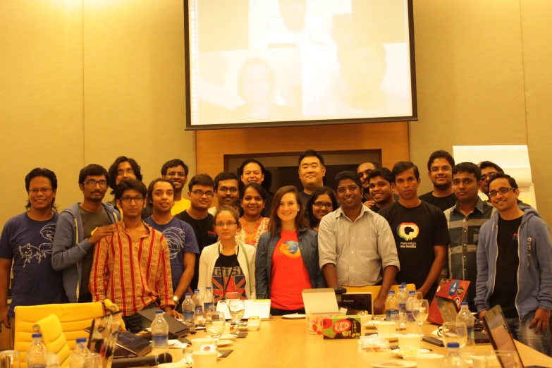 a group of people stand at the front of a long table