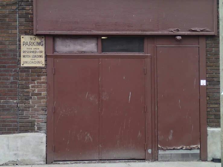 a large door to an old building near a sidewalk