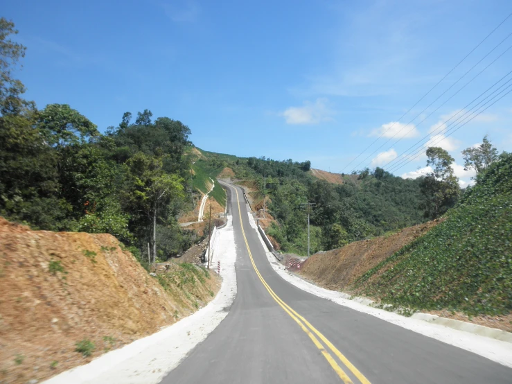 a long, winding road is shown on the side of a hill