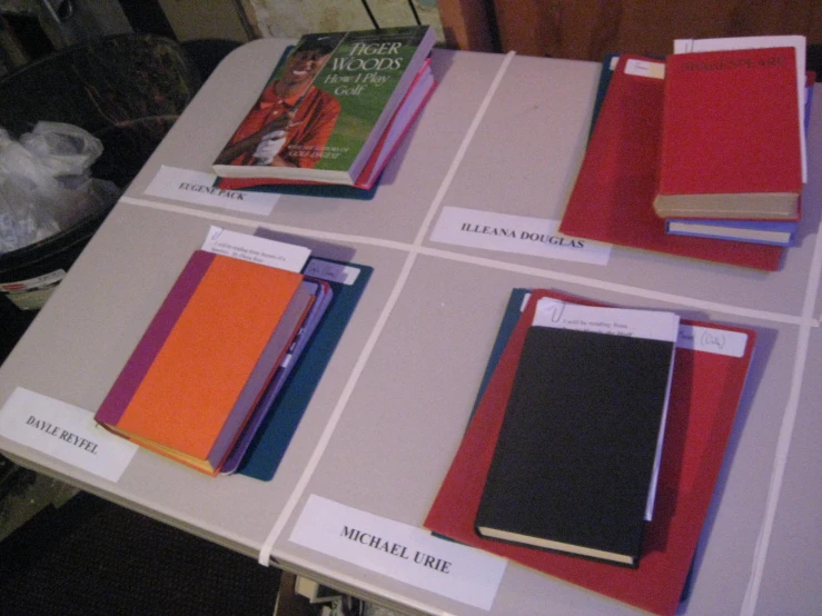 a row of red, blue, and yellow notebooks are on the table