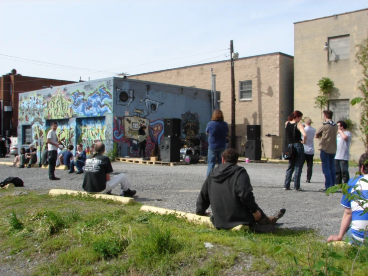 group of people sitting on the ground in front of a building