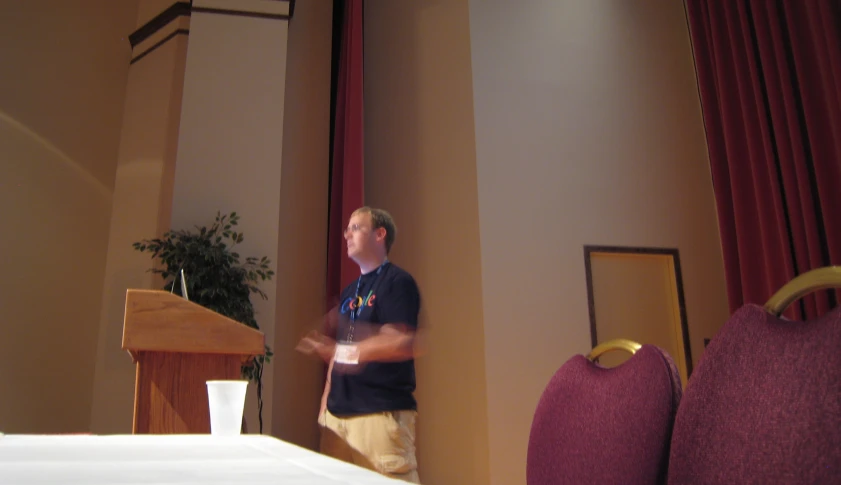 a man standing in front of a wooden podium talking