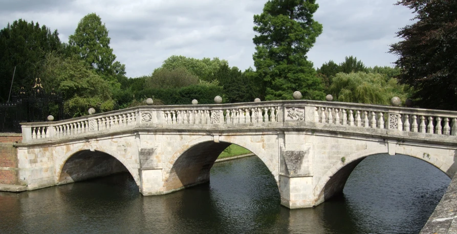 a stone bridge over a river with statues on top of it