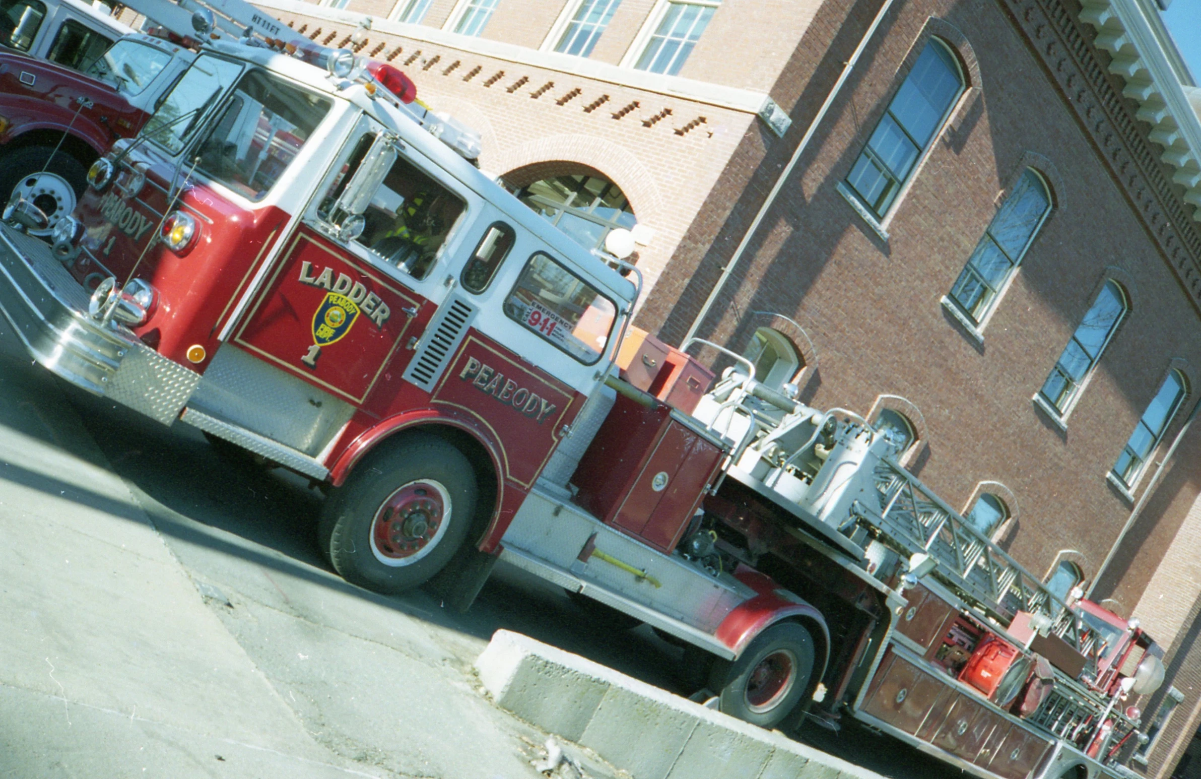 three red firetrucks are parked in front of the large brick building