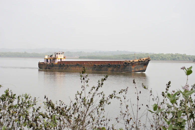 a large ship traveling across a lake on a cloudy day