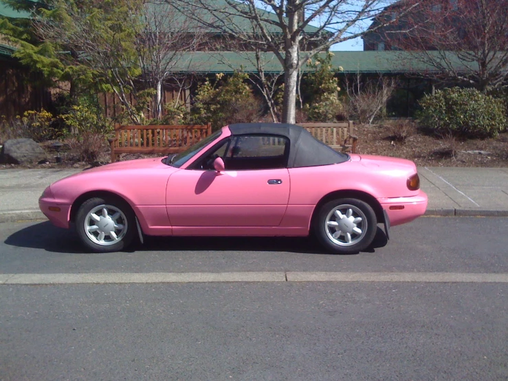a pink car is parked on the street