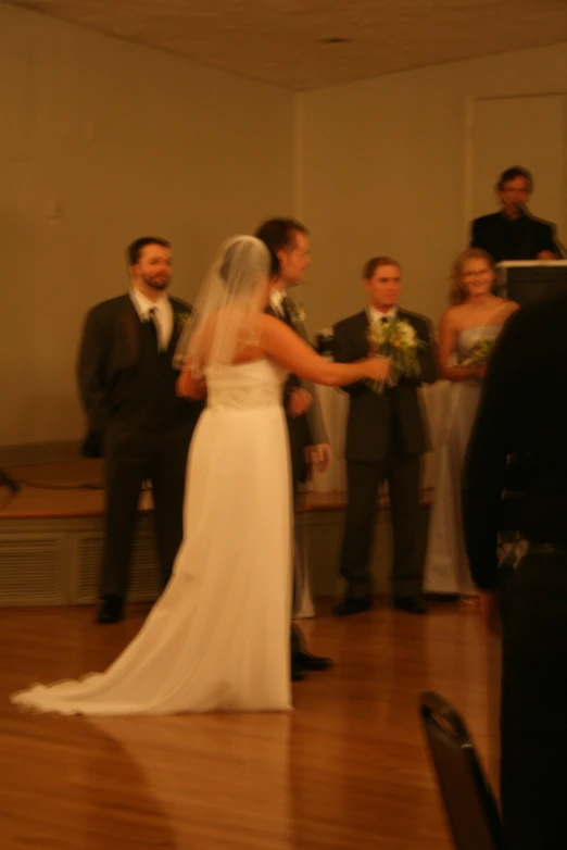 a bride and groom stand together in front of the altar as people look on