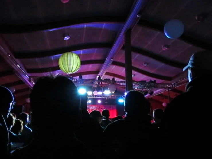 people on stage watching an illuminated balloon