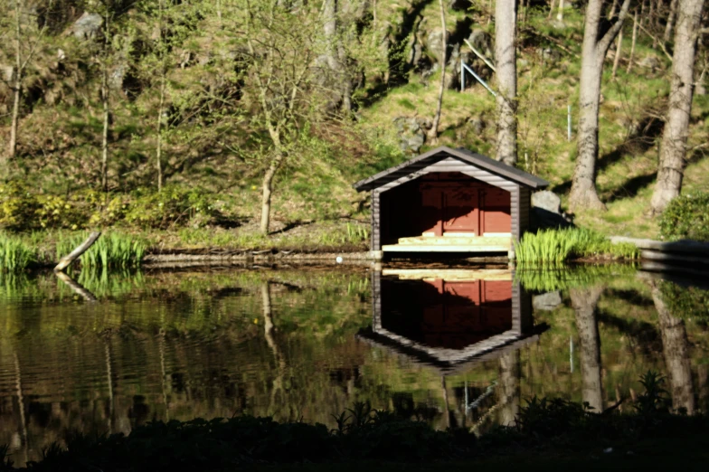 there is a shack in the water next to some trees