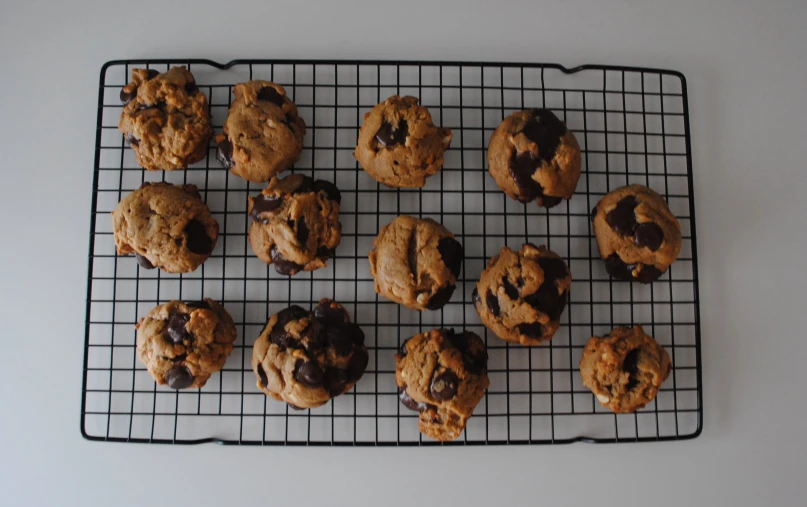 a metal cooling rack with different cookies on it