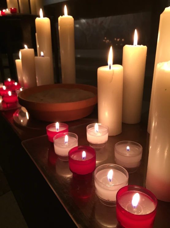 a table with many white and red candles
