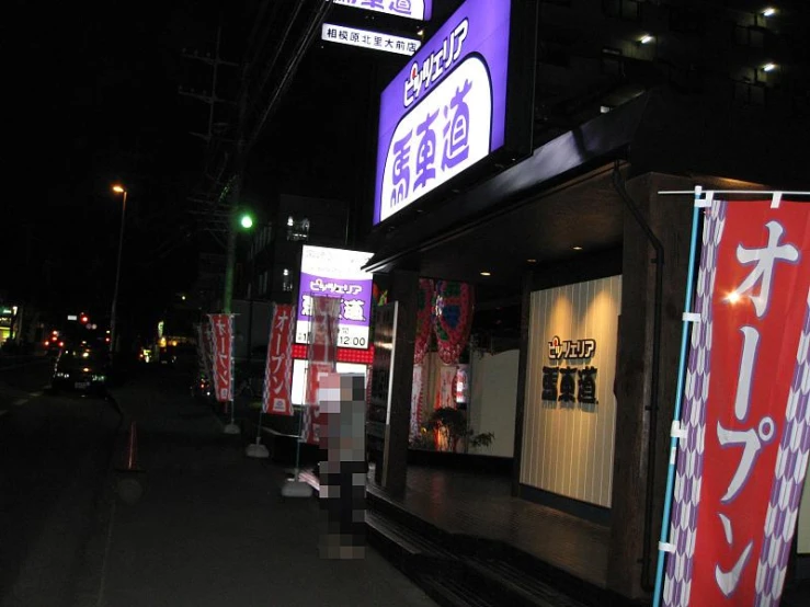 there are many lit up signs along the street