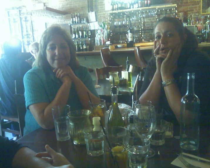 a couple sitting at a table filled with bottles of wine