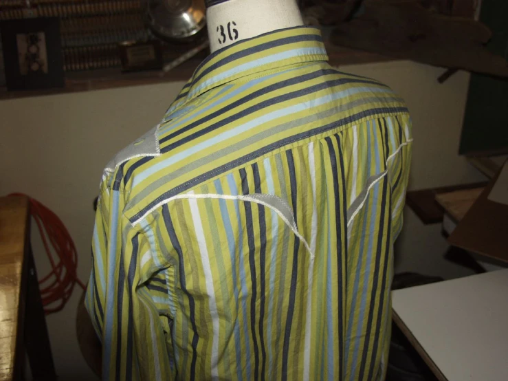 a mannequin that is wearing a green and black striped shirt