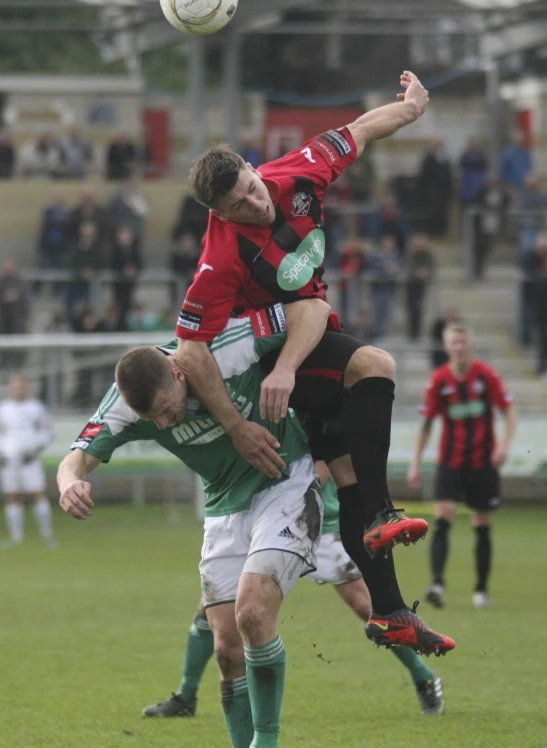 two men playing soccer against each other on a field