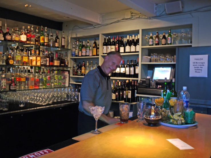 a man at a bar making drinks and smiling