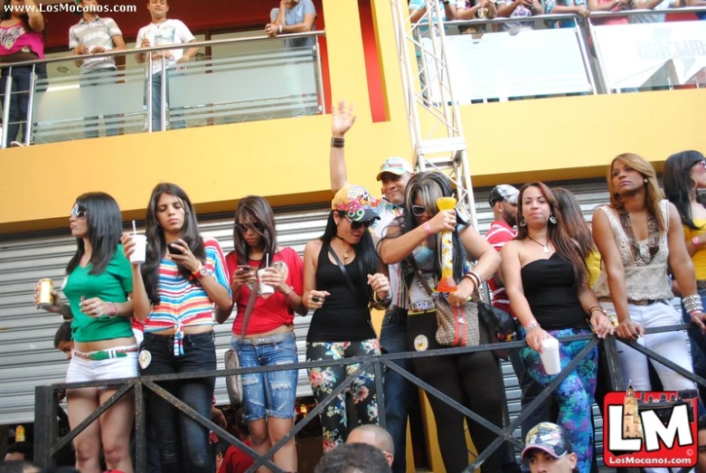 a group of woman holding their cameras up at a concert