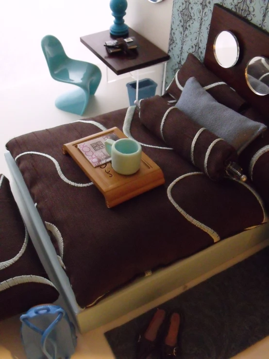 a bed with a brown and white comforter and a cup on it