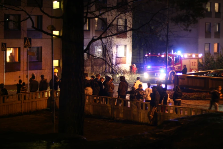 several people in front of firetruck at night