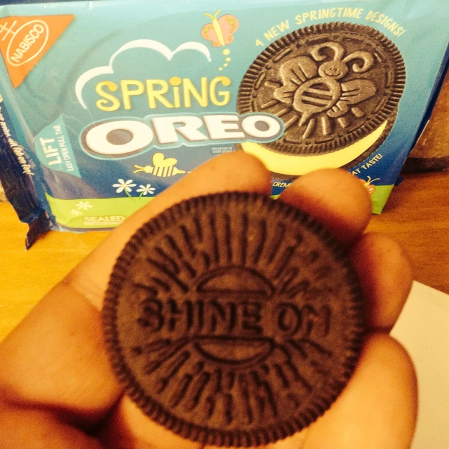someone holding a chocolate oreo in their hand