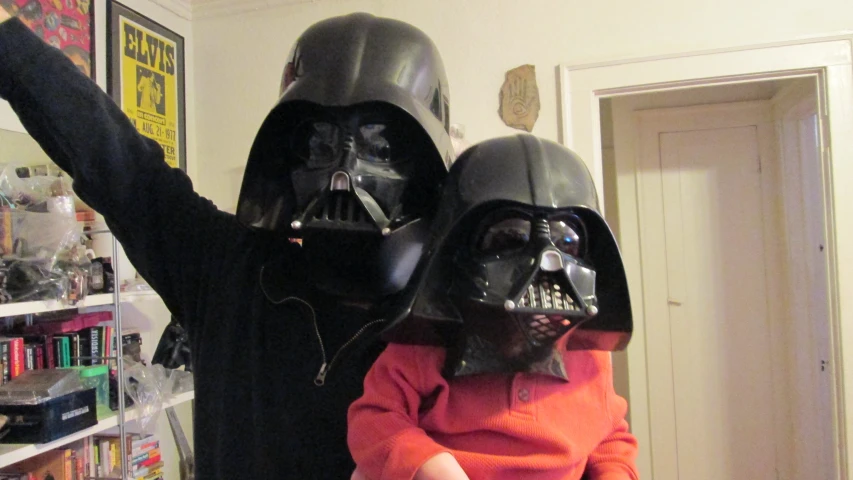 a man and a little girl in darth vader costumes