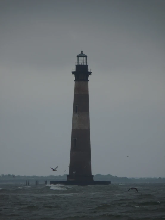 a large light house in the middle of the ocean