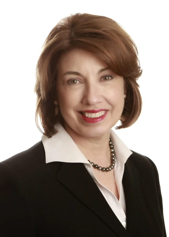 a smiling woman in black jacket with a white shirt on