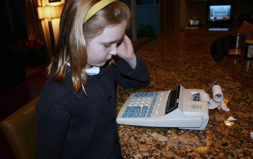 a girl with headbands near an old computer on the counter
